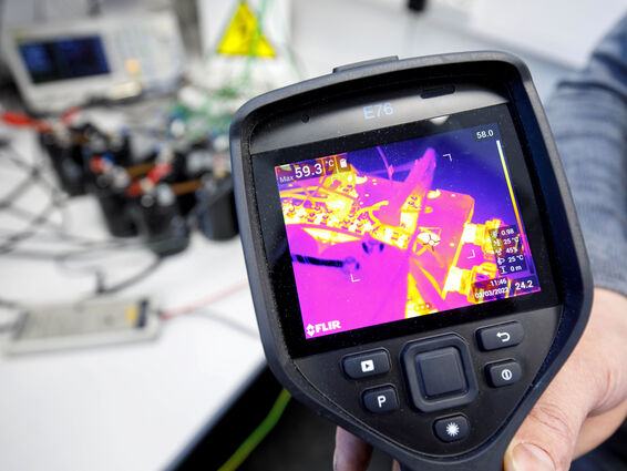 Employee checks a resistor using a thermal imaging camera